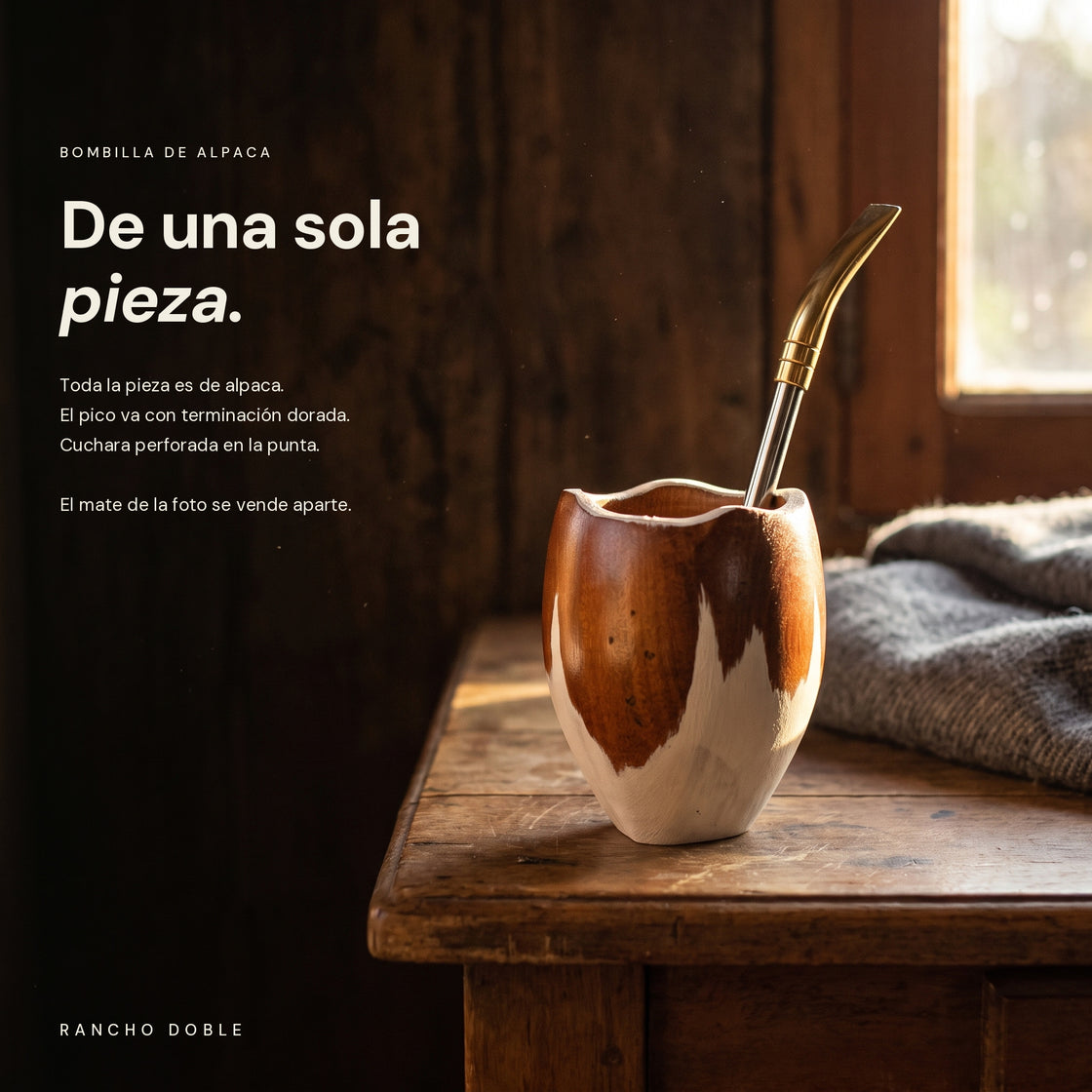 Bombilla de alpaca puesta en un mate de madera, sobre una mesa